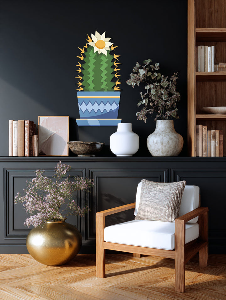 Light and shadow interplay across this decorative metal art, highlighting the whimsical flowering cactus in a colorful botanical modern design.
