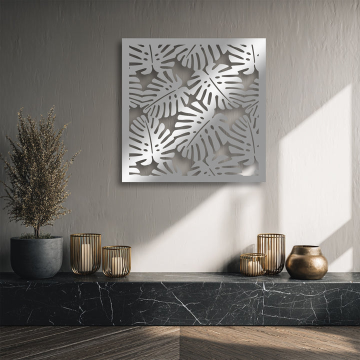 The negative space of a modern metal wall decor showcasing a striking Tropical Monstera Leaf Pattern on a textured wall.