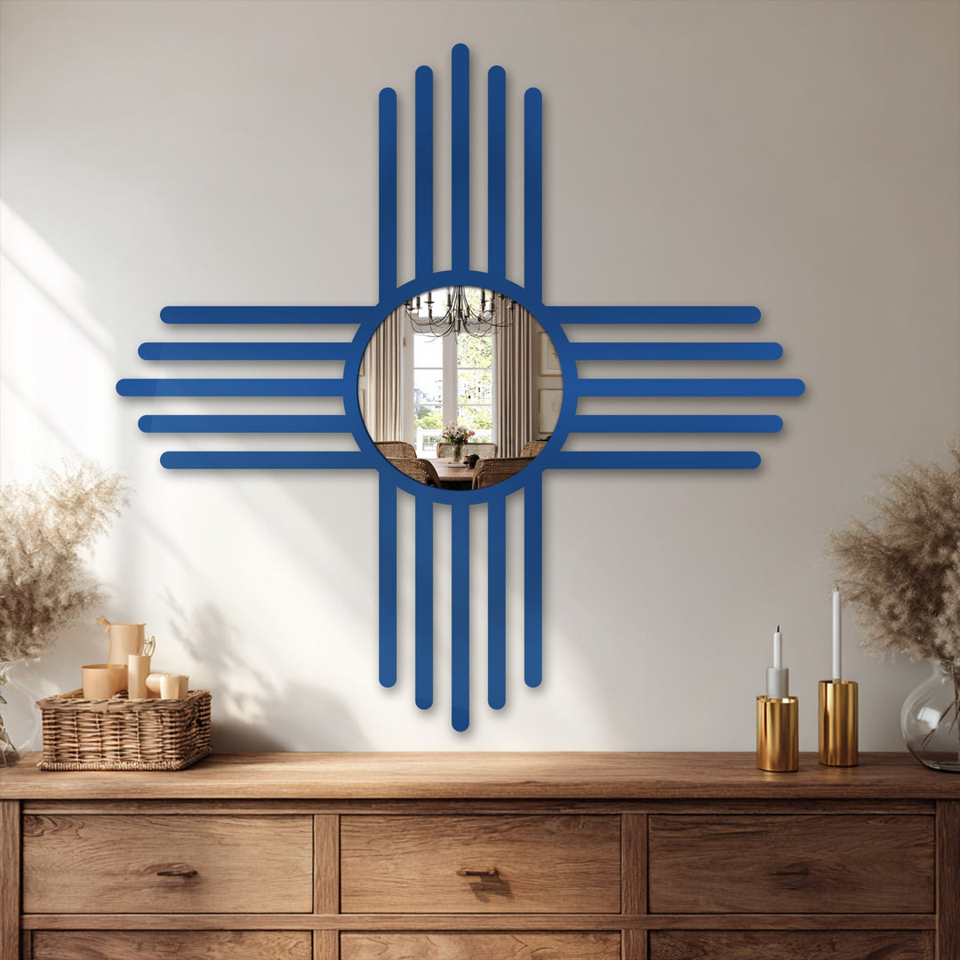 The ornate New Mexico Zia symbol-shaped bathroom mirror reflects a sunlit dining area on a wooden dresser, adding a focal point to enhance interior decor.