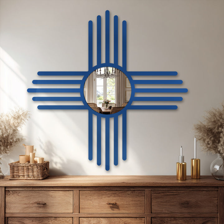 The ornate New Mexico Zia symbol-shaped bathroom mirror reflects a sunlit dining area on a wooden dresser, adding a focal point to enhance interior decor.