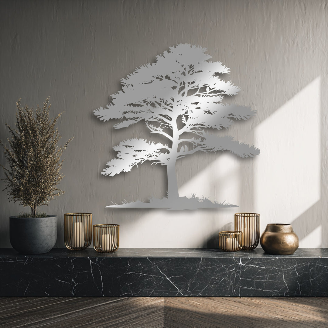 The polished black marble countertop, the darkest area, beautifully anchors the shimmering tree silhouette metal artwork, adding depth.