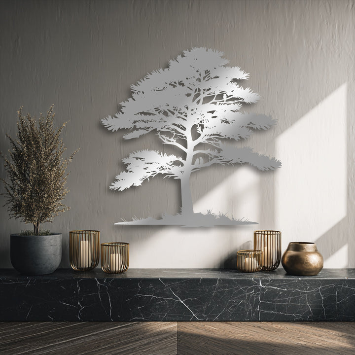 The polished black marble countertop, the darkest area, beautifully anchors the shimmering tree silhouette metal artwork, adding depth.
