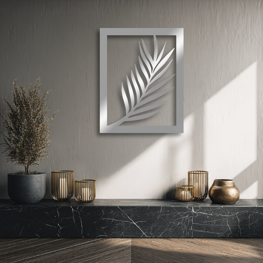 The sleek, reflective silver finish of the minimal palm leaf metal decoration wall art brightens the textured wall.