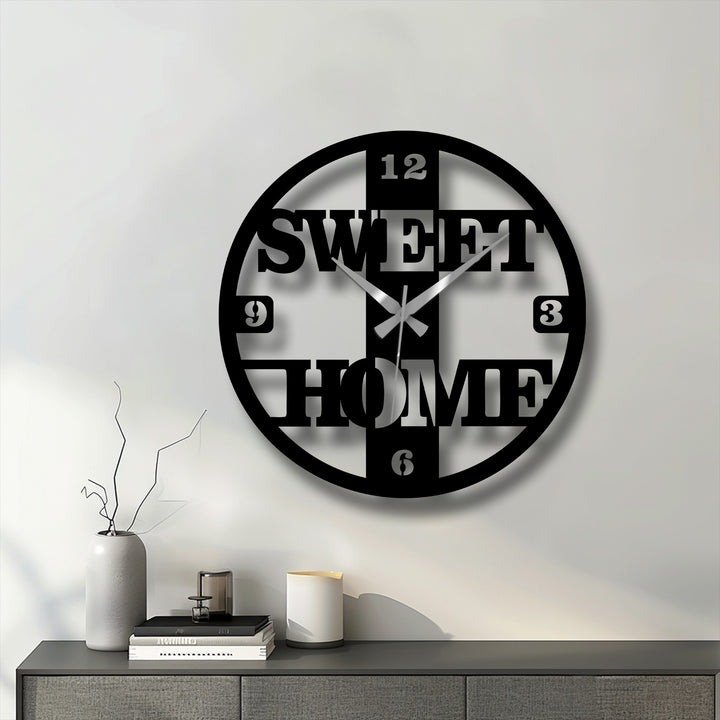 Featuring an edge and borders, the sweet home decorative metal art clock showcases a modern, round design with prominent numerals and lettering.