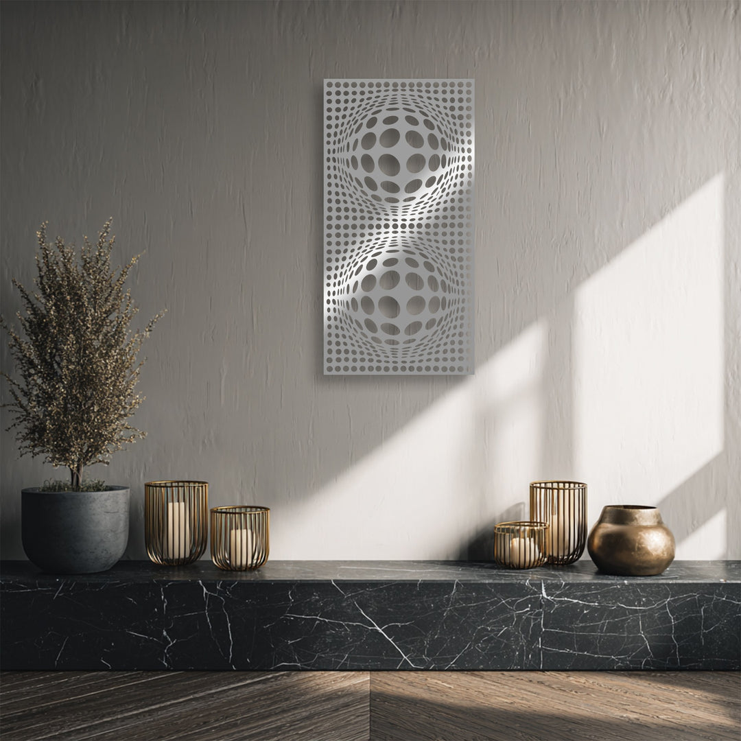 Subdued color saturation highlights the striking hypnotic orb geometry metal wall decor, flanked by a dried plant and bronze vessels.