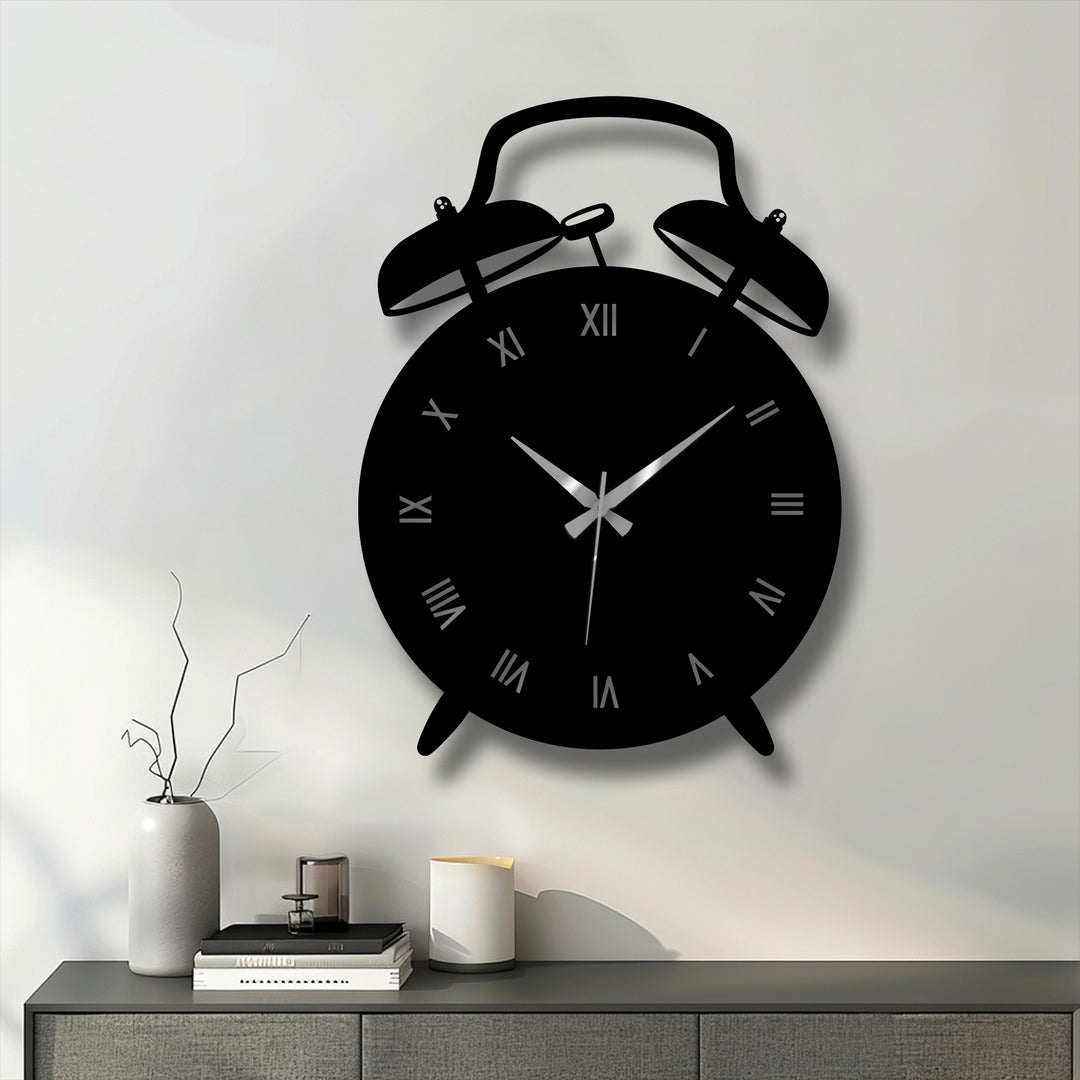 Foreground view of a vintage alarm clock-shaped decorative metal art clock featuring Roman numerals on a gray cabinet in a modern room.