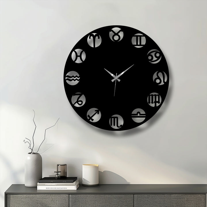 A cool, crisp light illuminates a sleek black Zodiac Symbol Metal Wall Clock, showcasing its modern astrological metal wall decor.