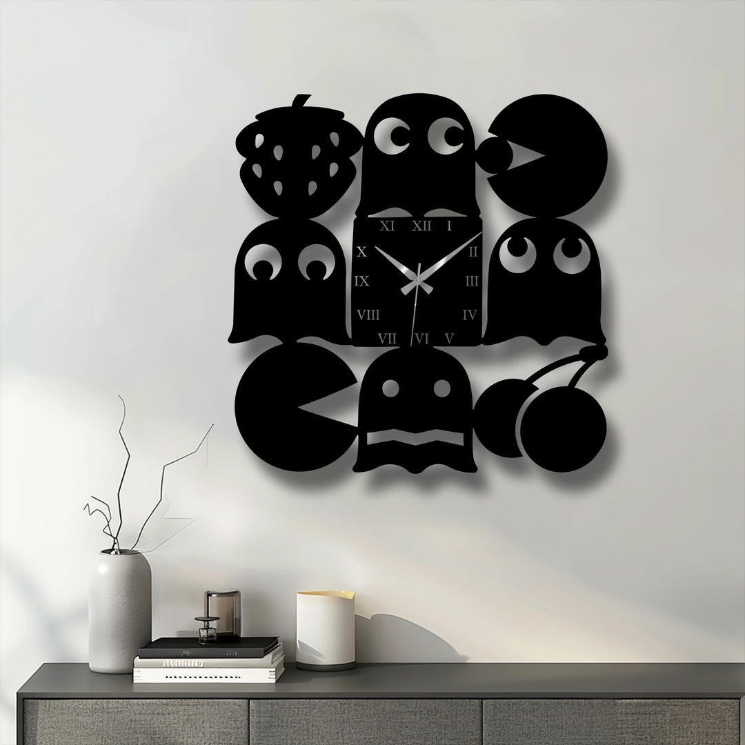 A gray vase with branches, stacked books, and a white candle are on a cabinet below the playful metal wall decor.