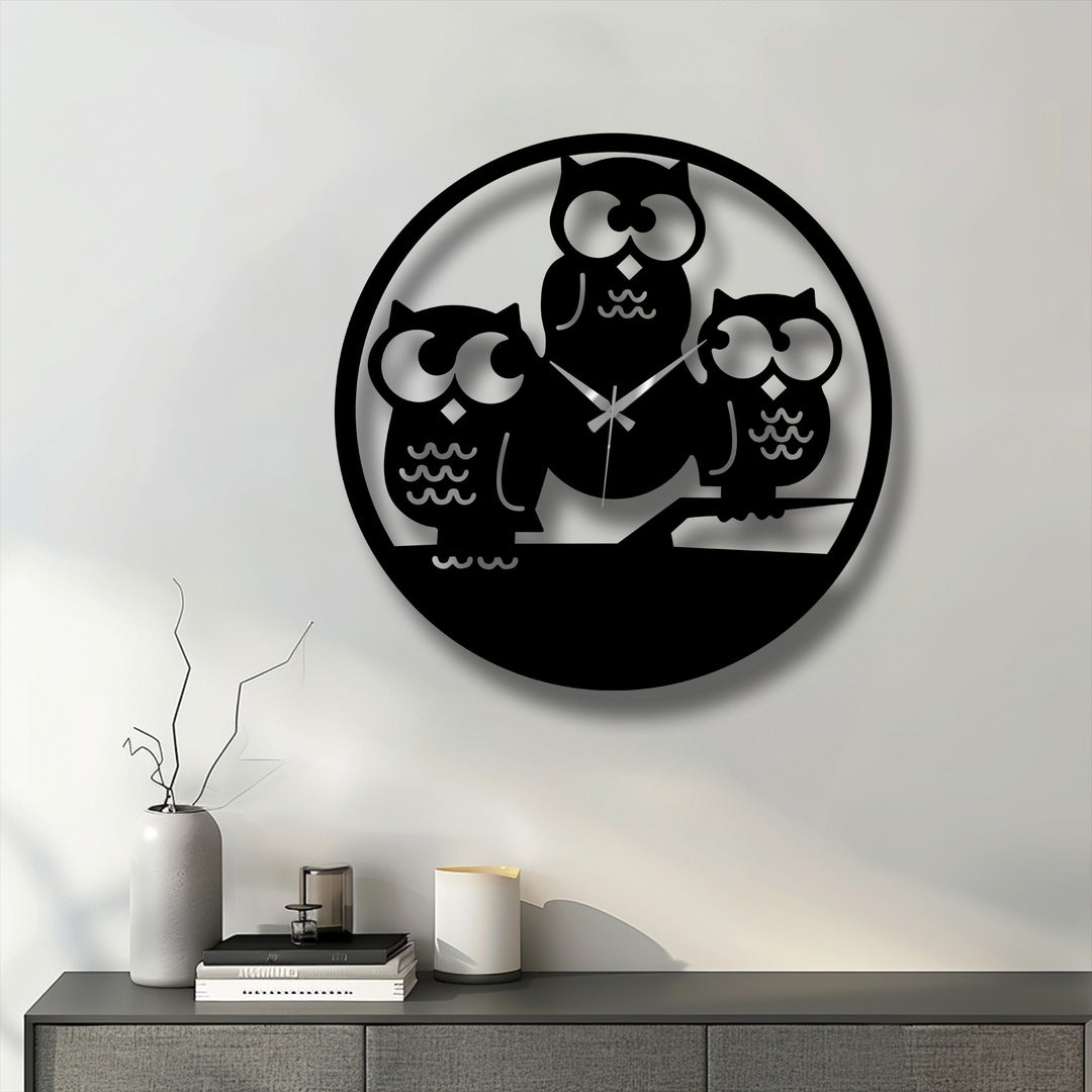 Low color saturation defines this unique metal wall art, a Three Owls Silhouette Metal Wall Clock, sharply contrasting black against a bright white wall.