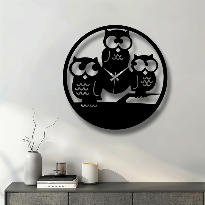 Low color saturation defines this unique metal wall art, a Three Owls Silhouette Metal Wall Clock, sharply contrasting black against a bright white wall.