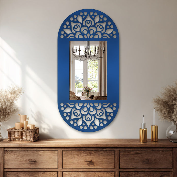 Reflecting off the bathroom mirror, the bright window illuminates the floral mandala pattern of this oval floor mirror's decorative metal frame.