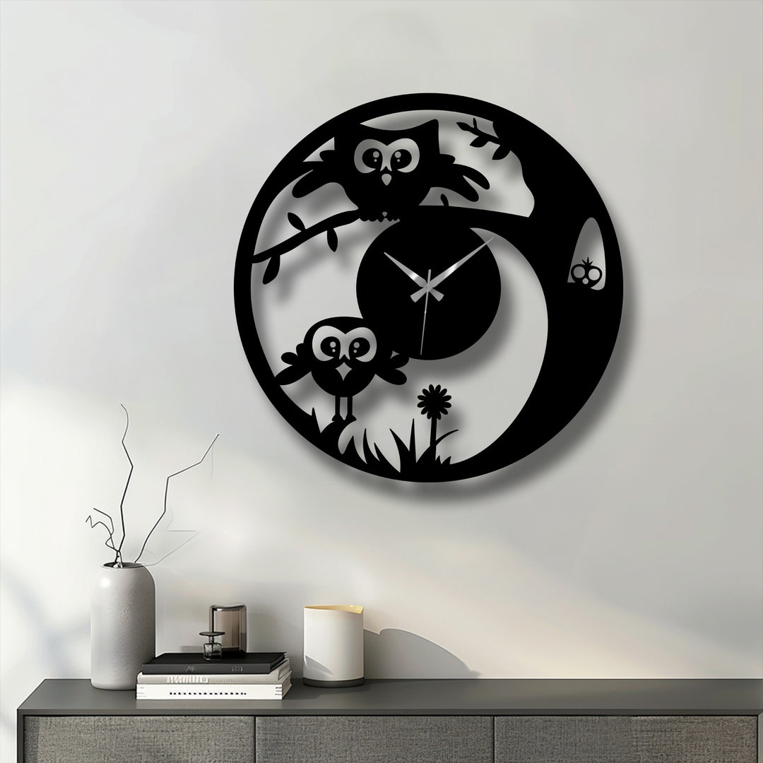 Against a simple, neutral background, a black, decorative metal art cute owl wall clock casts a soft shadow on the wall.