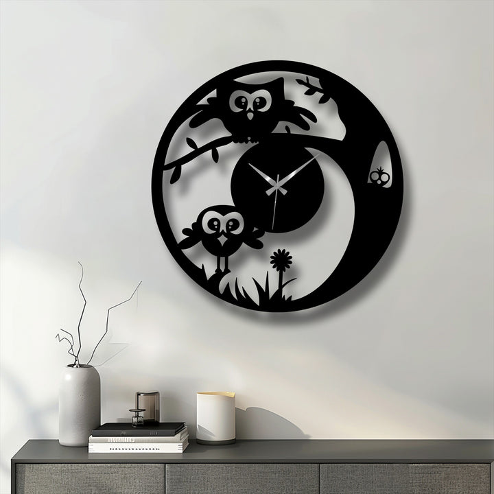 Against a simple, neutral background, a black, decorative metal art cute owl wall clock casts a soft shadow on the wall.