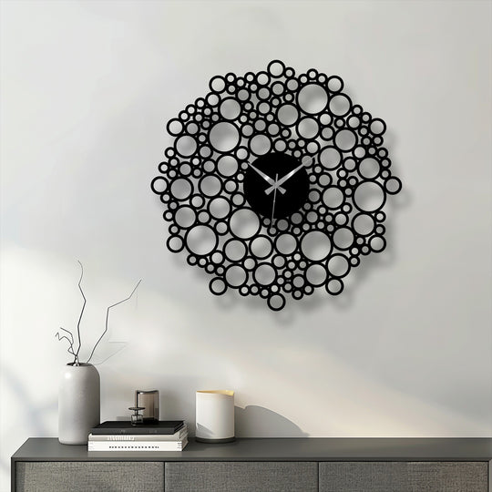 Illuminating the wall, the bright reflection draws attention to the striking bubble mesh design of this modern metal artwork clock with geometric circles.
