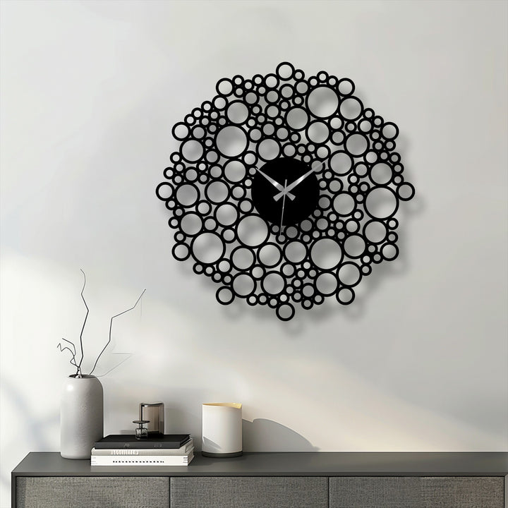 Illuminating the wall, the bright reflection draws attention to the striking bubble mesh design of this modern metal artwork clock with geometric circles.