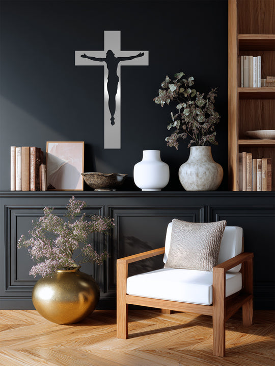 Shadows highlight the transition between colors in this decorative metal art piece, a minimalist crucifix featuring a silhouette of Jesus in polished metal.
