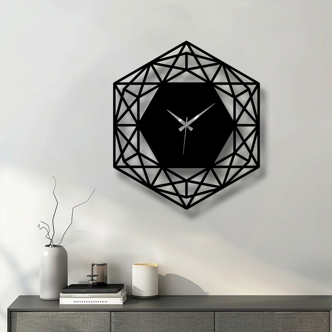 The bold, black geometric hexagon metal wall clock with its intricate design serves as unique metal wall art, casting a shadow on the light wall.