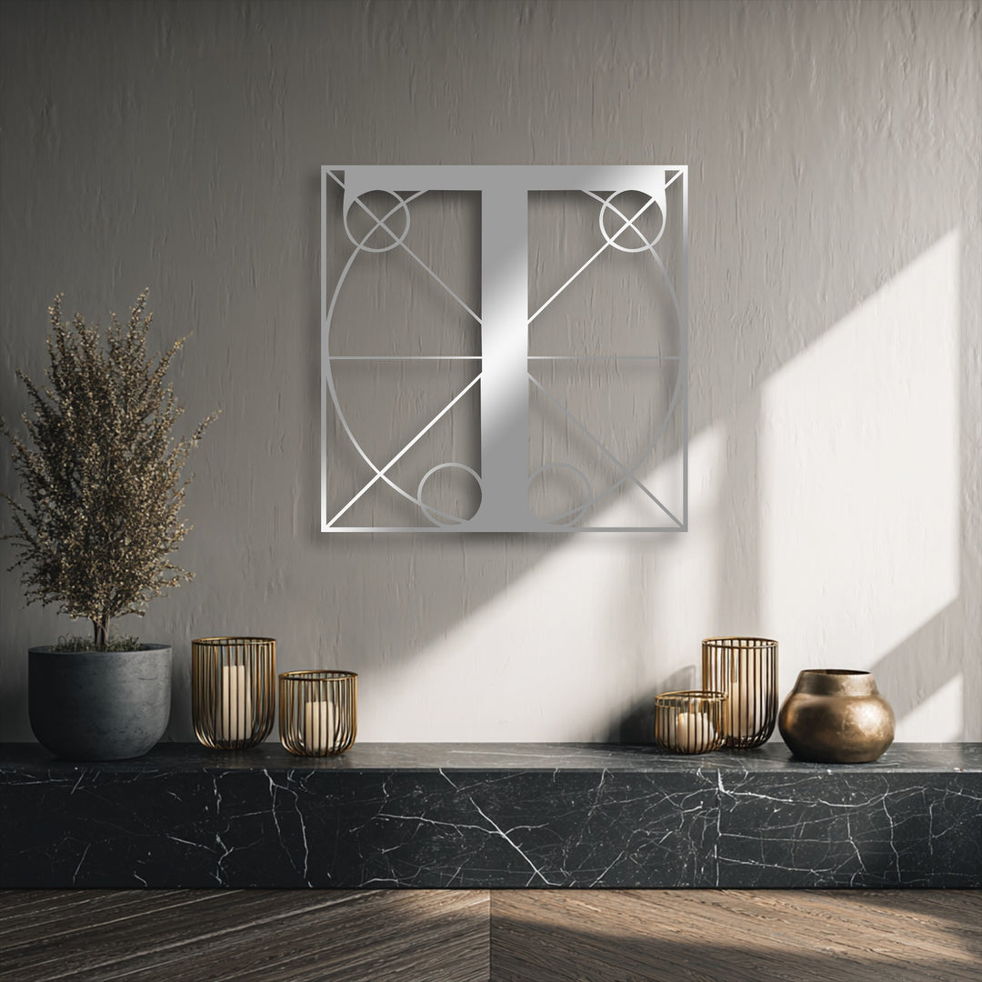 The textured gray background wall, softly lit by sunlight and featuring a crisp shadow, enhances the modern geometric letter T metal decoration wall art.