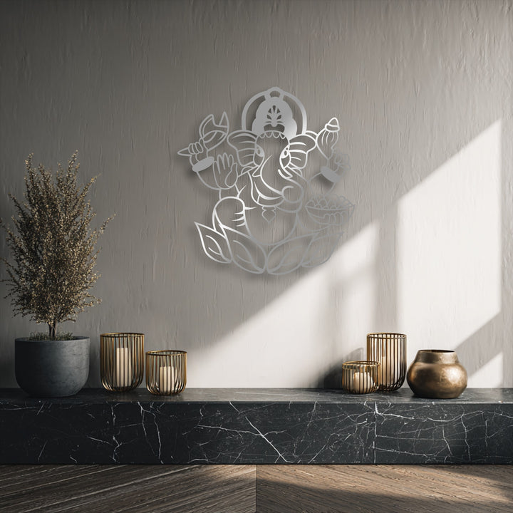 The organic forms of this decorative metal art depict a sacred Ganesha, an elephant deity, seated peacefully on a stylized lotus.