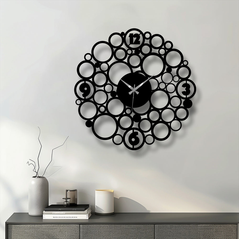 Shadows define the unique metal wall art circle design, creating a contrast as the dark bubble clock subtly shifts to lighter tones.