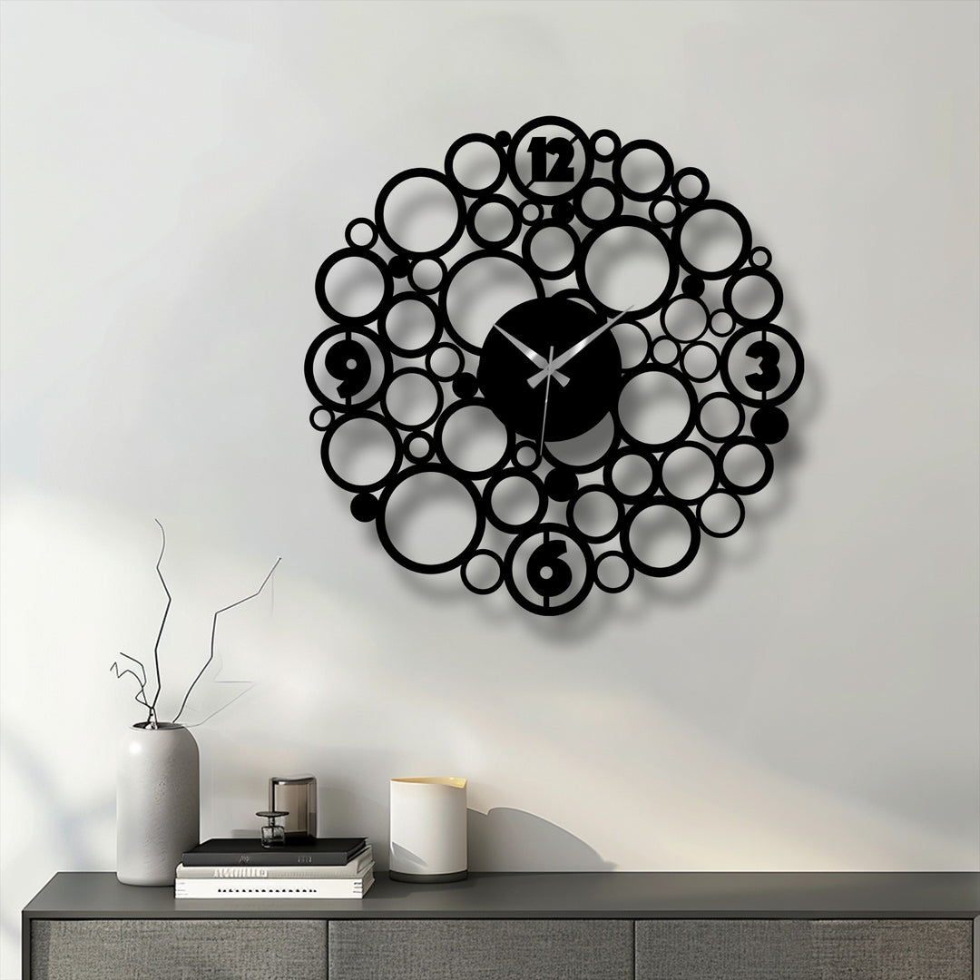 Shadows define the unique metal wall art circle design, creating a contrast as the dark bubble clock subtly shifts to lighter tones.