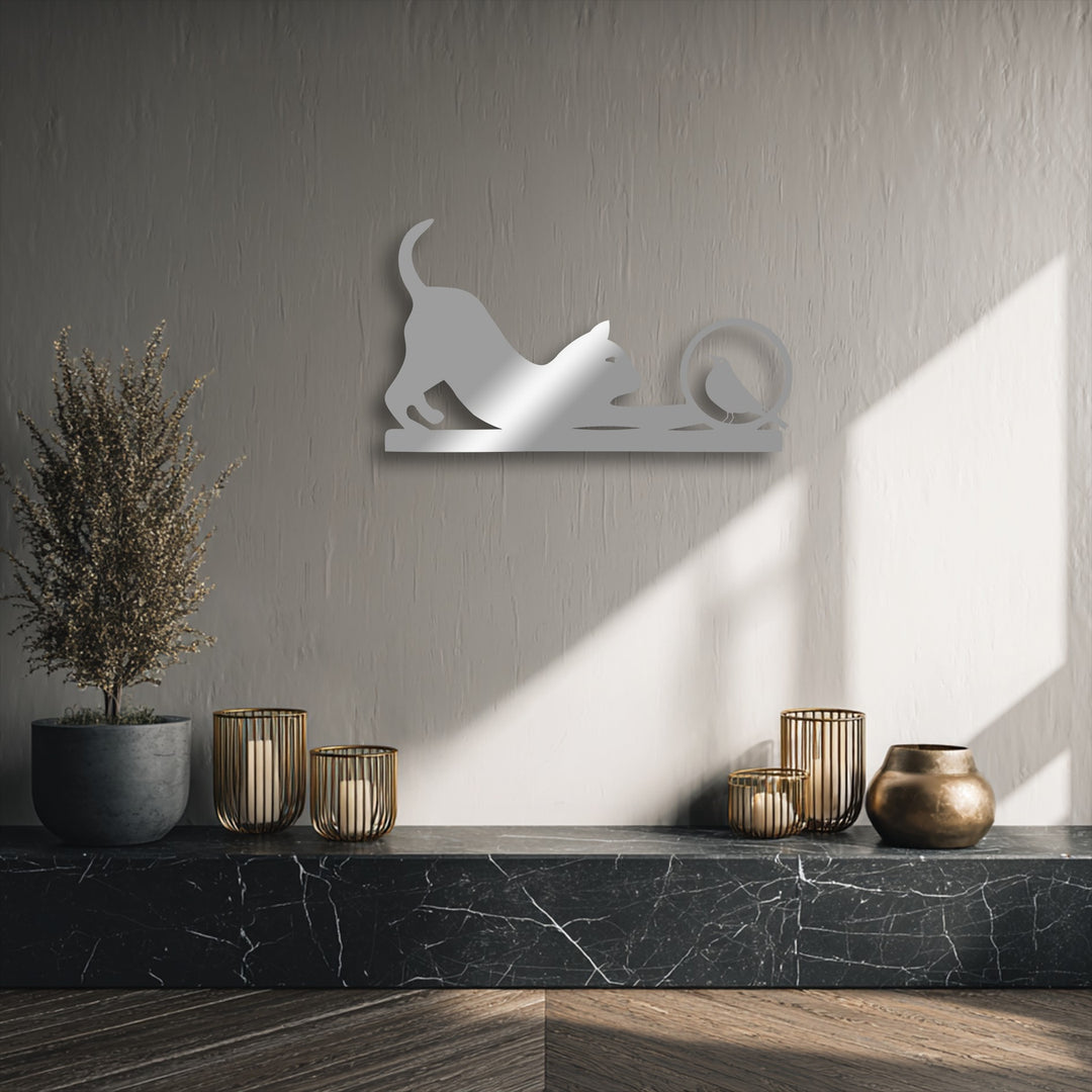 The unique metal wall art of a playful cat and bird is smooth and reflective against the subtly textured wall and veined marble.