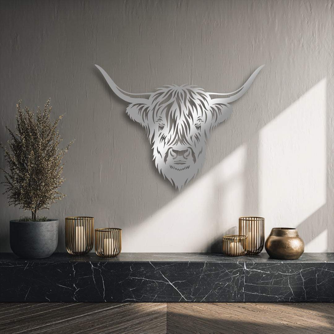 With subdued color saturation, this decorative metal art of a Majestic Highland Bull Head sits above a dark marble shelf.