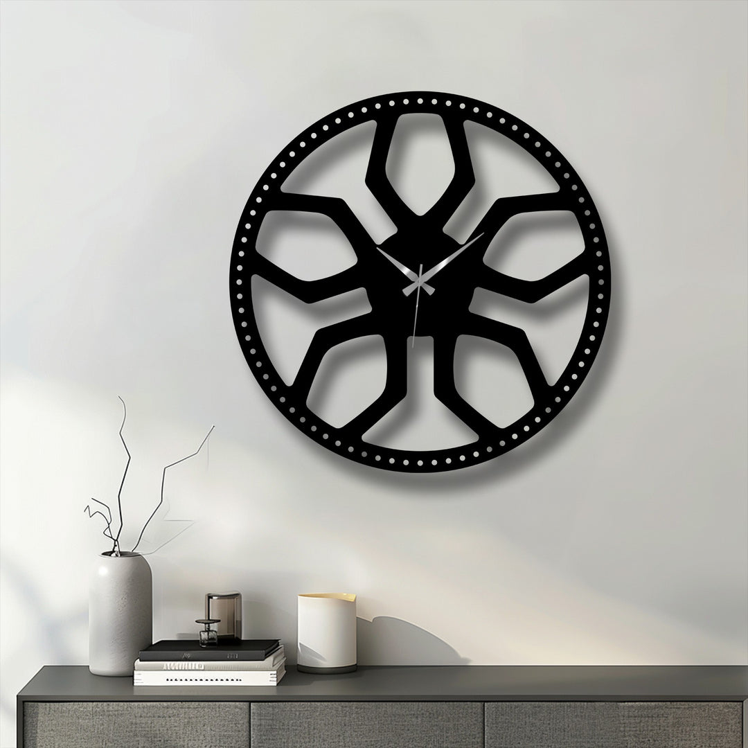The crisp off-white dominant color highlights a striking black abstract radial pattern metal artwork clock, featuring a modern geometric design.