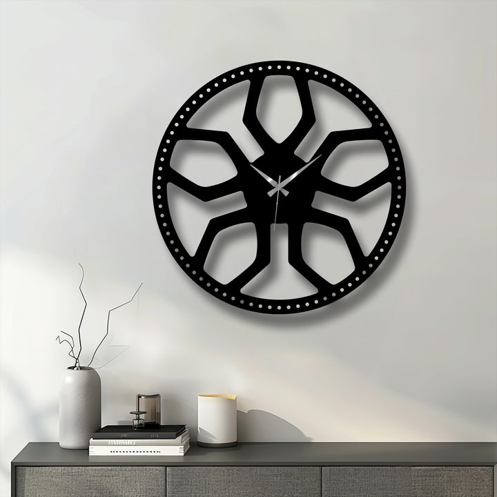 The crisp off-white dominant color highlights a striking black abstract radial pattern metal artwork clock, featuring a modern geometric design.