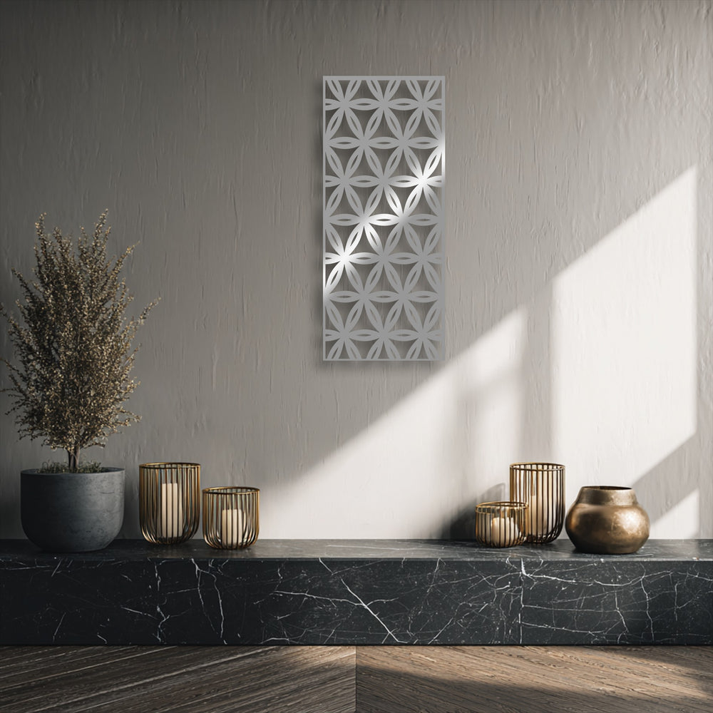 Witness the striking color transition on the textured wall, shifting from deep grey to brilliant sunlit white around the geometric floral metal wall decor.