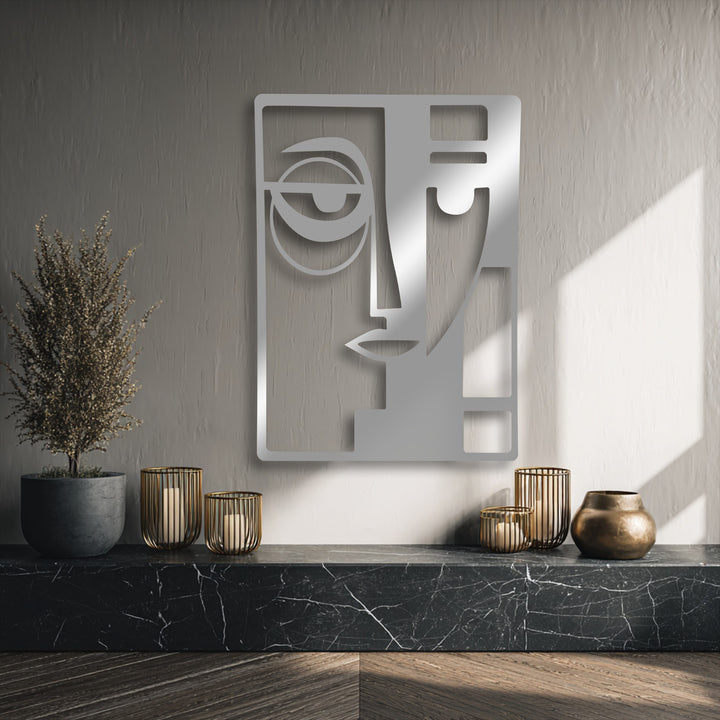 The dominant muted stone grey background highlights a reflective silver Abstract Dual Face unique metal wall art.