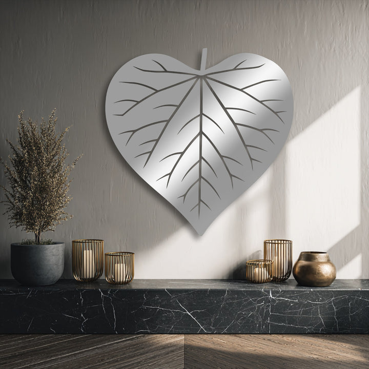 Against a softly textured, light beige background wall, a rectangular sunbeam illuminates the elegant leaf silhouette decoration wall art.