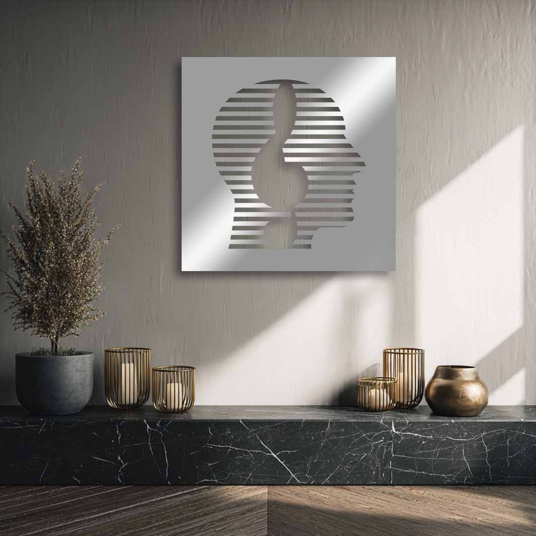 This decorative metal art, an abstract face, adds depth and layers to the wall, above a dark marble display.