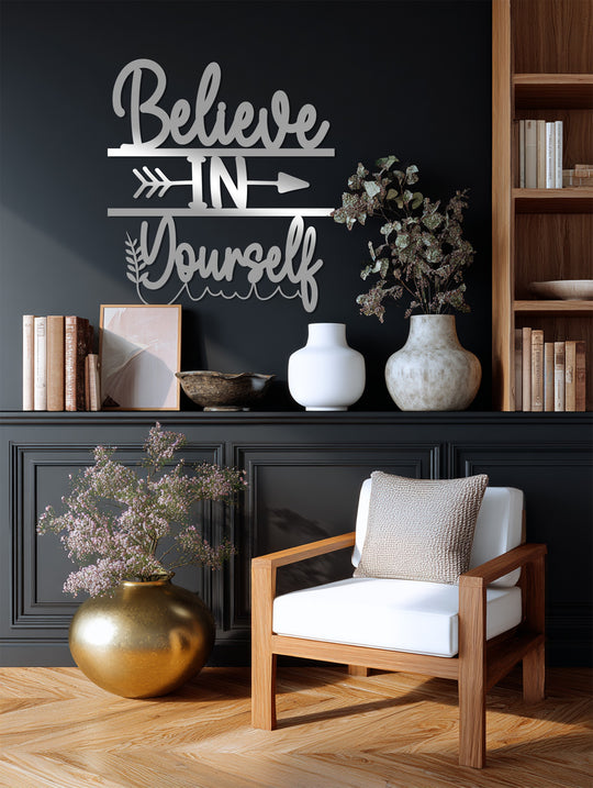 A minimalist decorative metal art piece features a stylized 'Believe in Yourself' quote with an arrow element.