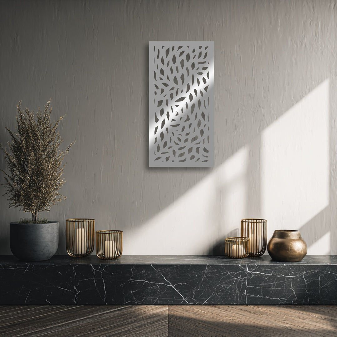 Vertically oriented, rectangular metal artwork featuring an intricate abstract leaf pattern cut into its surface.