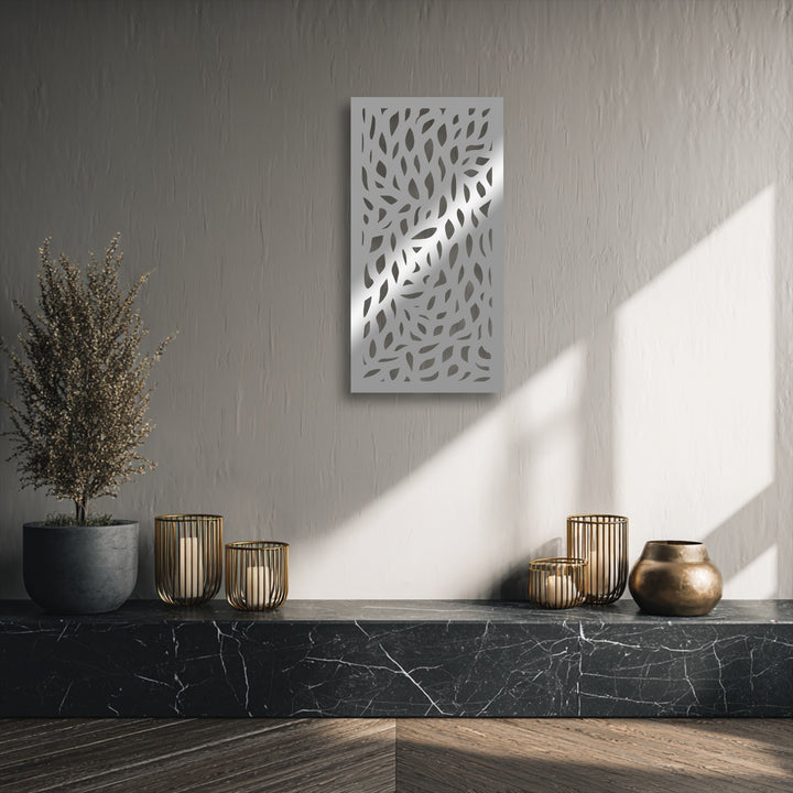 Vertically oriented, rectangular metal artwork featuring an intricate abstract leaf pattern cut into its surface.