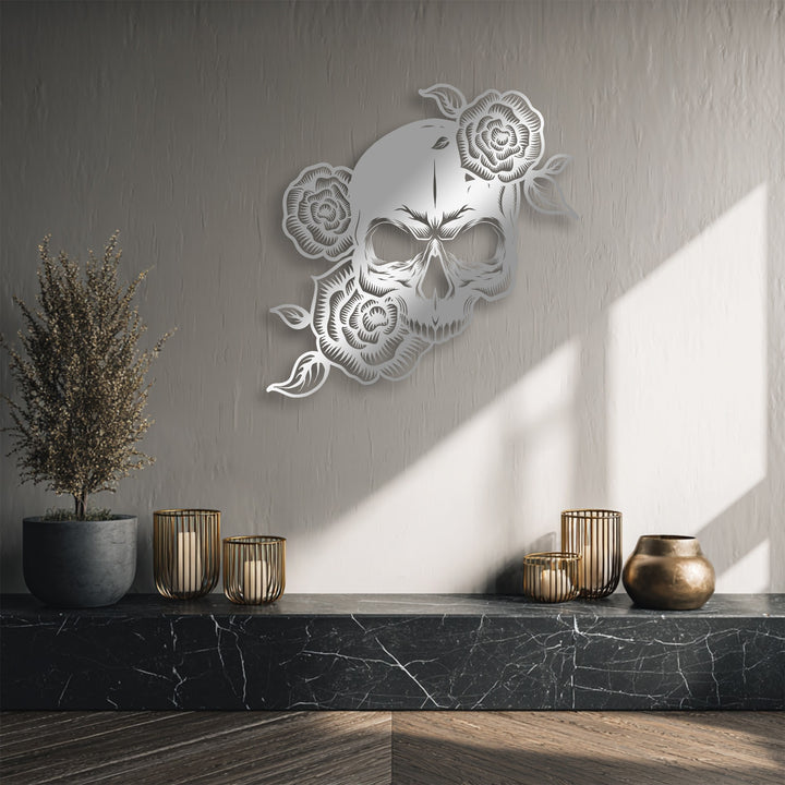 The brightly sunlit wall, illuminated with strong diagonal light, highlights the intricate details of the gothic floral skull metal wall decor.