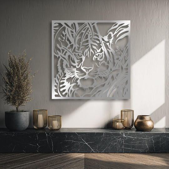The striking color contrast of the lustrous silver Jungle Gaze tiger metal art for wall against the muted grey background creates a captivating focal point.