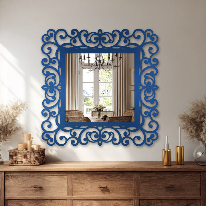 Reflecting a dining space, the smooth surface texture of this ornate blue framed wall mirror features intricate scrollwork, enhancing the elegant, classic design with a bold color.