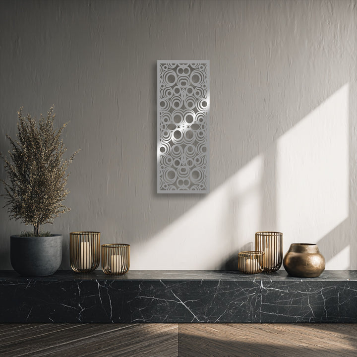 Striking color contrast between the light geometric circle decorative metal art and dark black marble base creates a focal point.