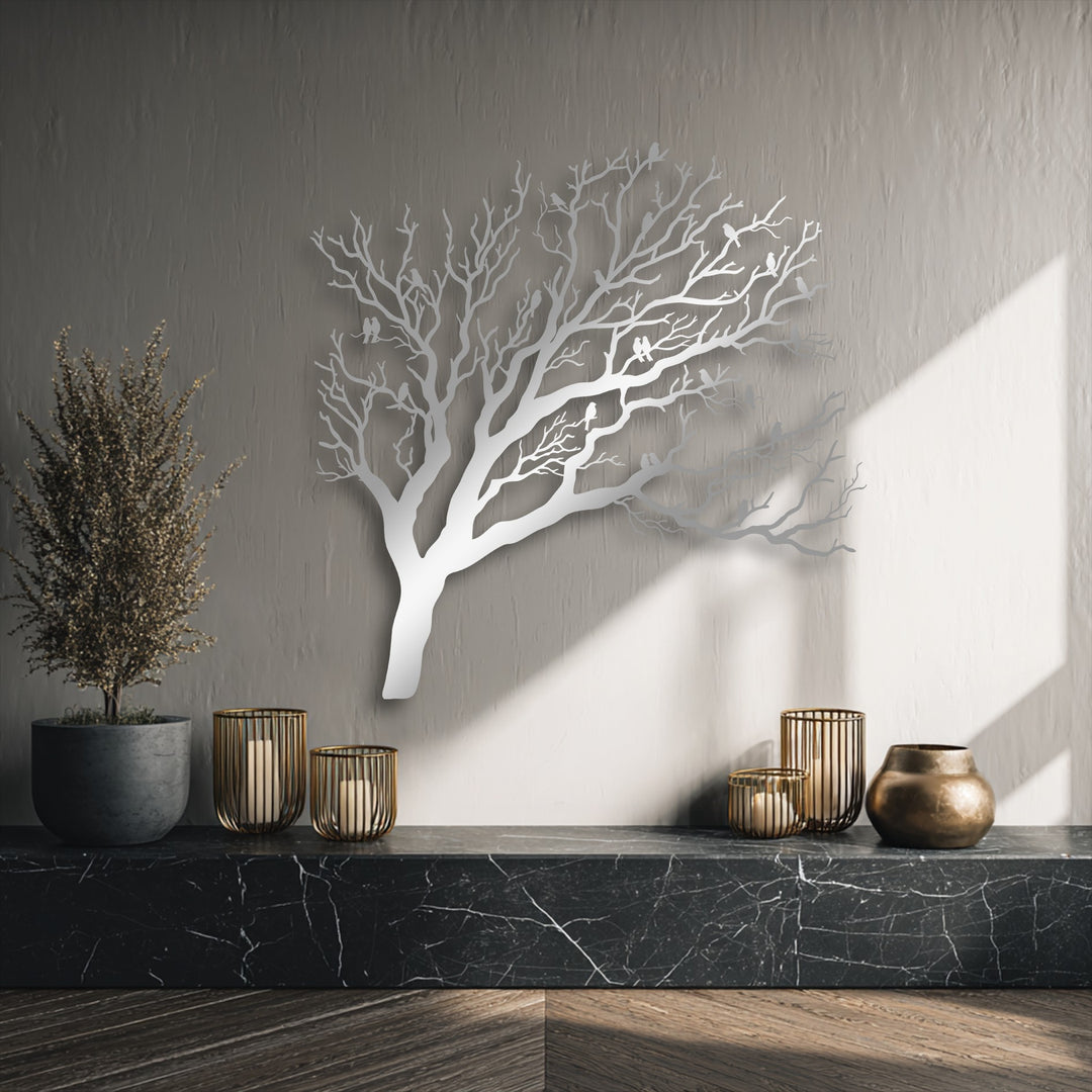 The layering effect is showcased by this elegant decorative metal art of a tree with birds, casting dynamic shadows against the neutral wall.
