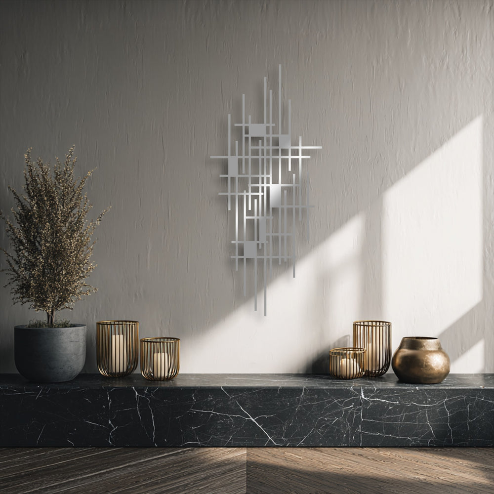 A wispy, dried plant provides a soft counterpoint to the sharp lines of the modern geometric grid metal wall decor, bathed in gentle sunlight.