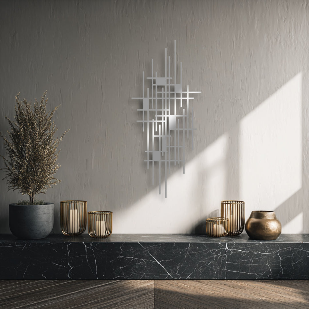 A wispy, dried plant provides a soft counterpoint to the sharp lines of the modern geometric grid metal wall decor, bathed in gentle sunlight.