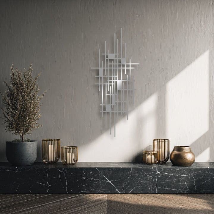 A wispy, dried plant provides a soft counterpoint to the sharp lines of the modern geometric grid metal wall decor, bathed in gentle sunlight.
