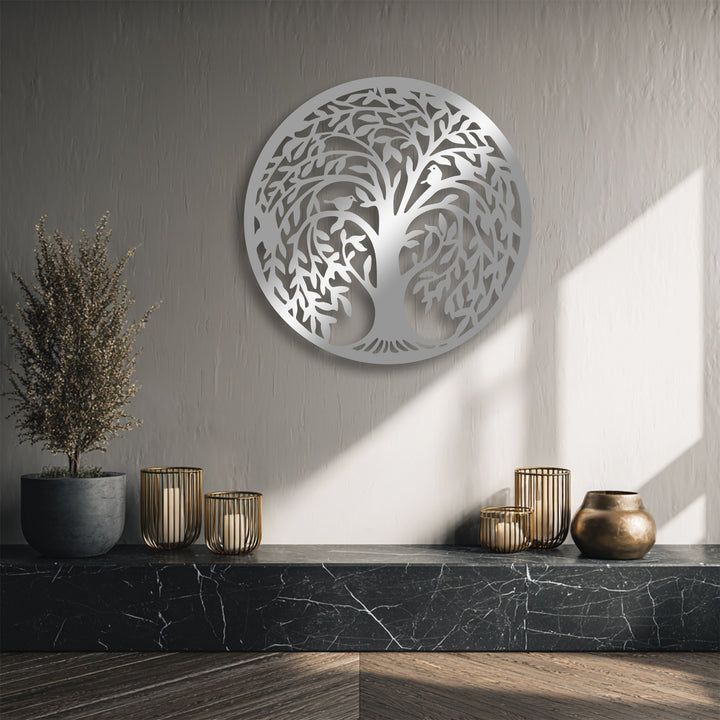 The stillness of a textured wall highlights the intricate round Tree of Life metal wall decor amidst calm light and shadow.
