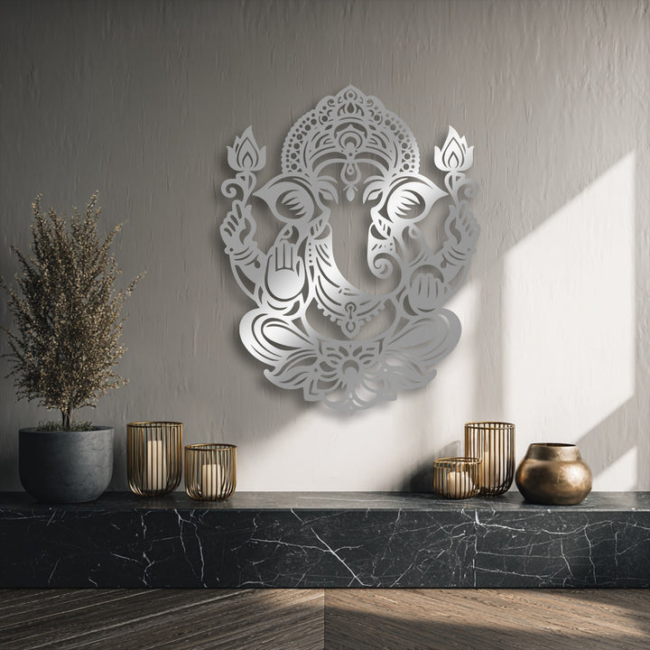 The stillness is conveyed by a detailed Ganesha Lotus decorative metal art, gently lit on a wall above a dark marble shelf.