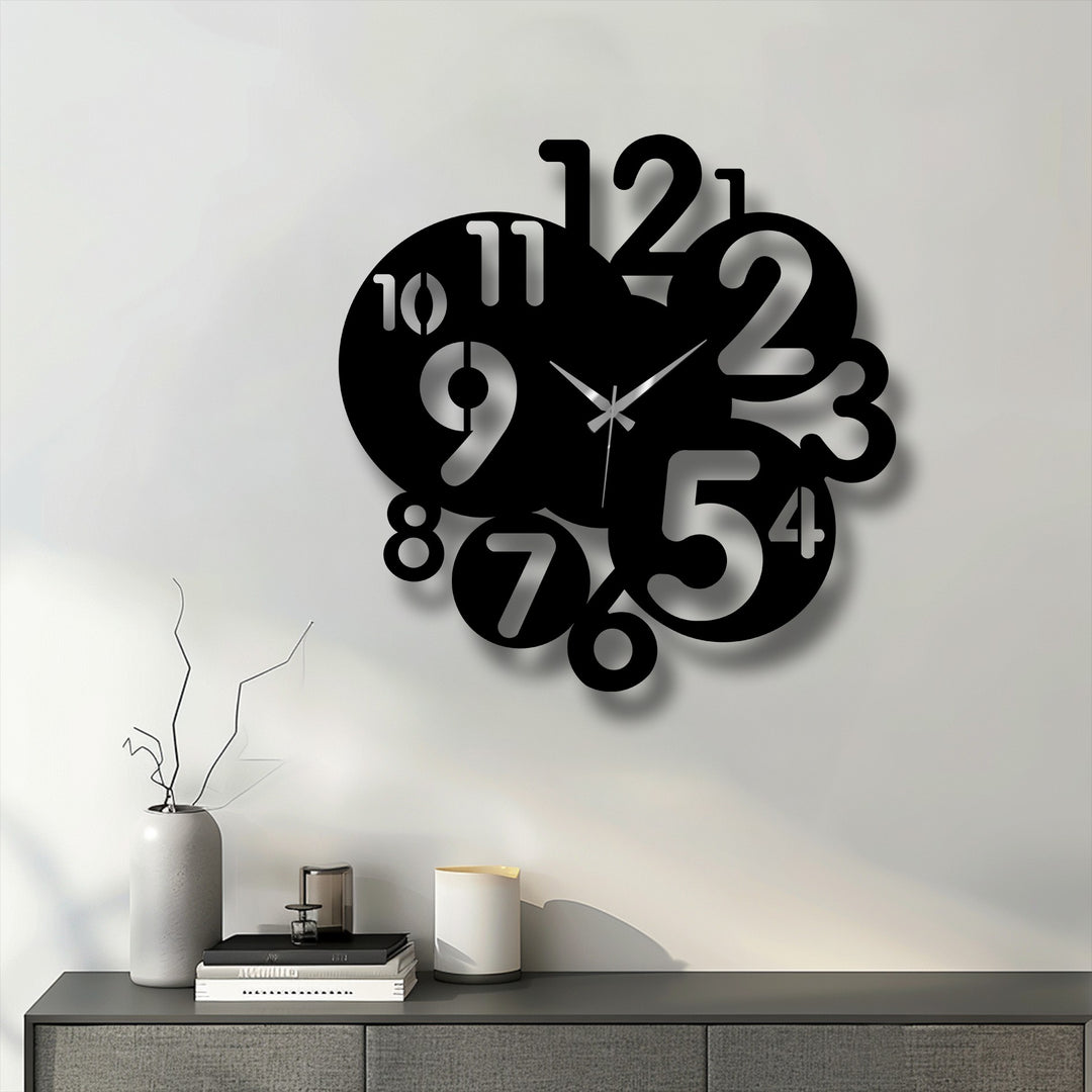 Negative space on the white wall dramatically emphasizes the bold, abstract design of this modern number art metal artwork clock.