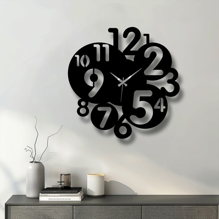 Negative space on the white wall dramatically emphasizes the bold, abstract design of this modern number art metal artwork clock.