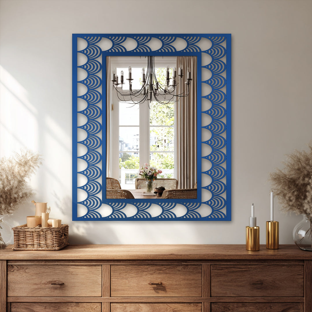 Boldly framed with an Art Deco wave pattern, the sapphire-toned mirror for wall decor reflects a well-lit dining space, creating an opulent and artistic focal point.
