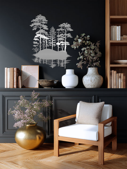 Warm, ambient lighting highlights the silver tones of the tranquil forest reflection metal art for wall, contrasting with the cool, dark wall behind it.